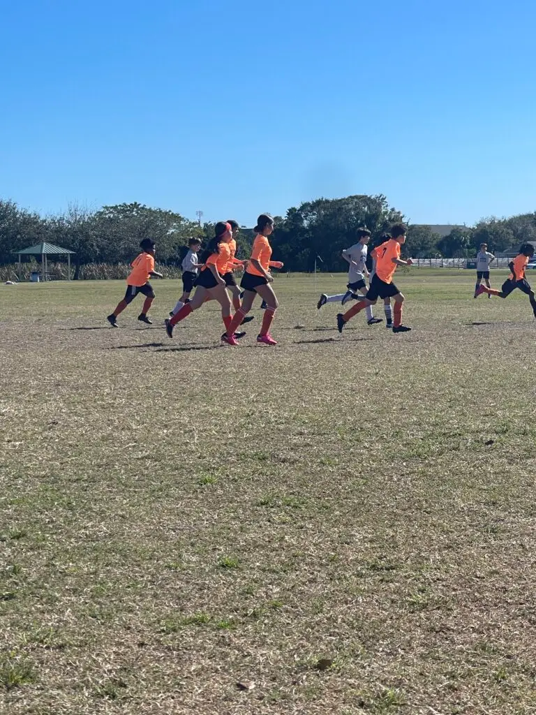 BCS soccer team sprinting down the field during a game
