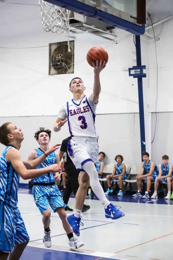 BCS high school basketball player leaps for a layup during a game