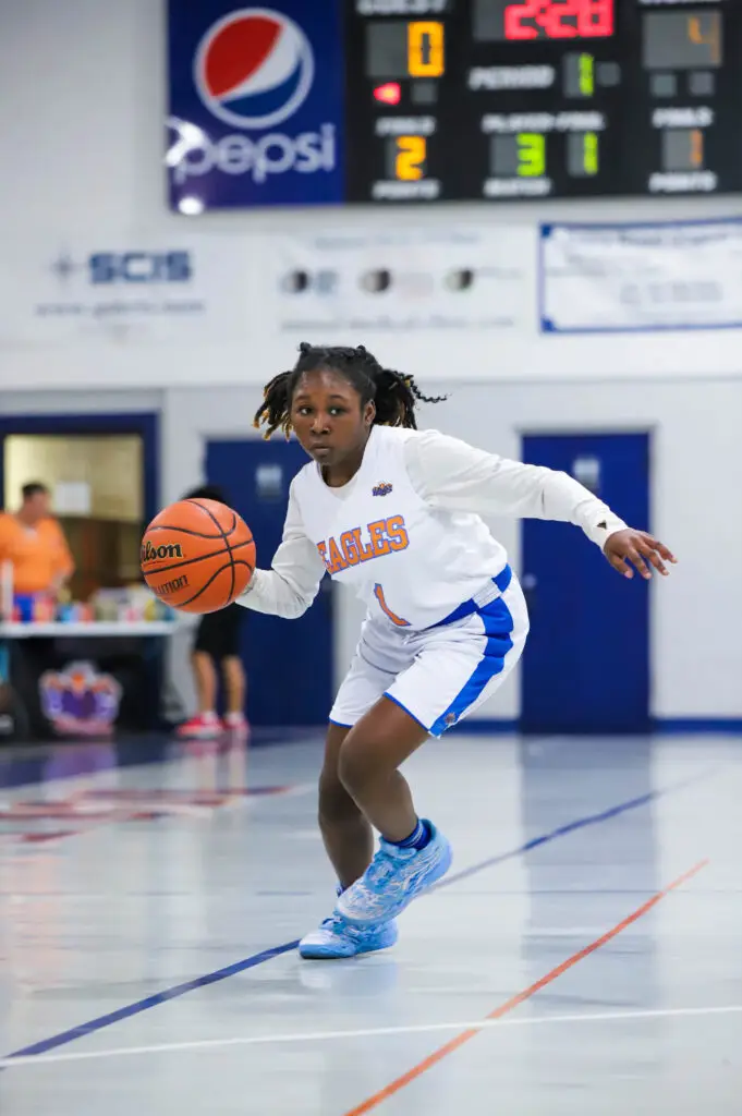 BCS girls basketball player moves the ball with intensity during a game