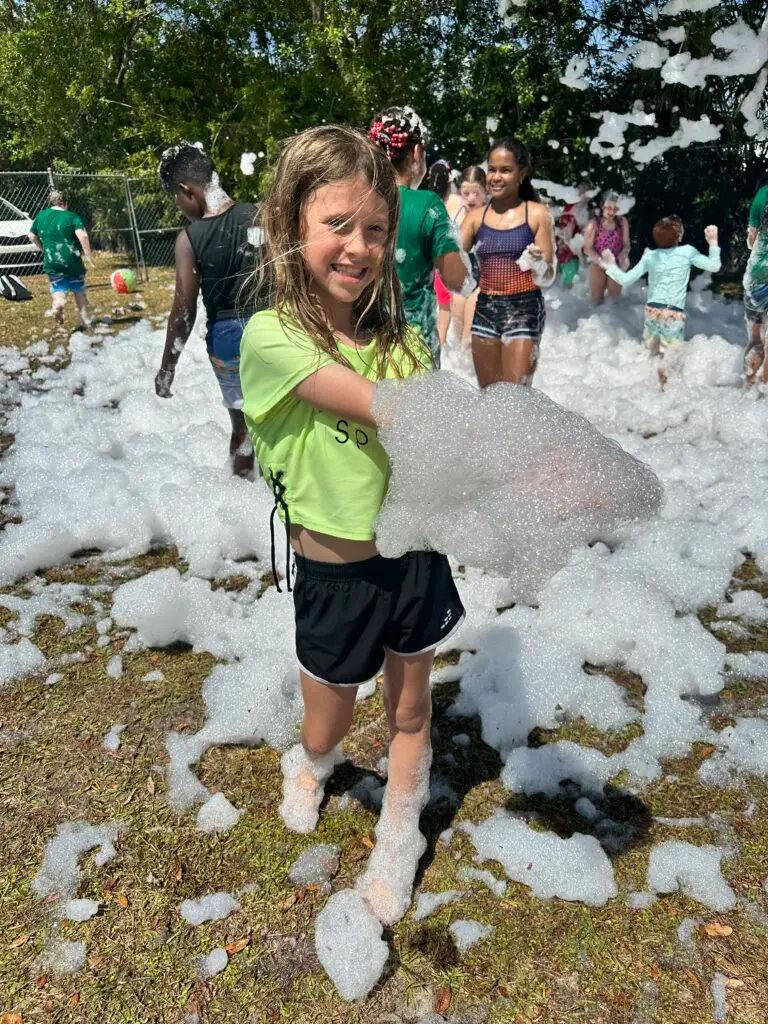 Elementary student playing in bubbles during Field Day at Bethany Christian School.