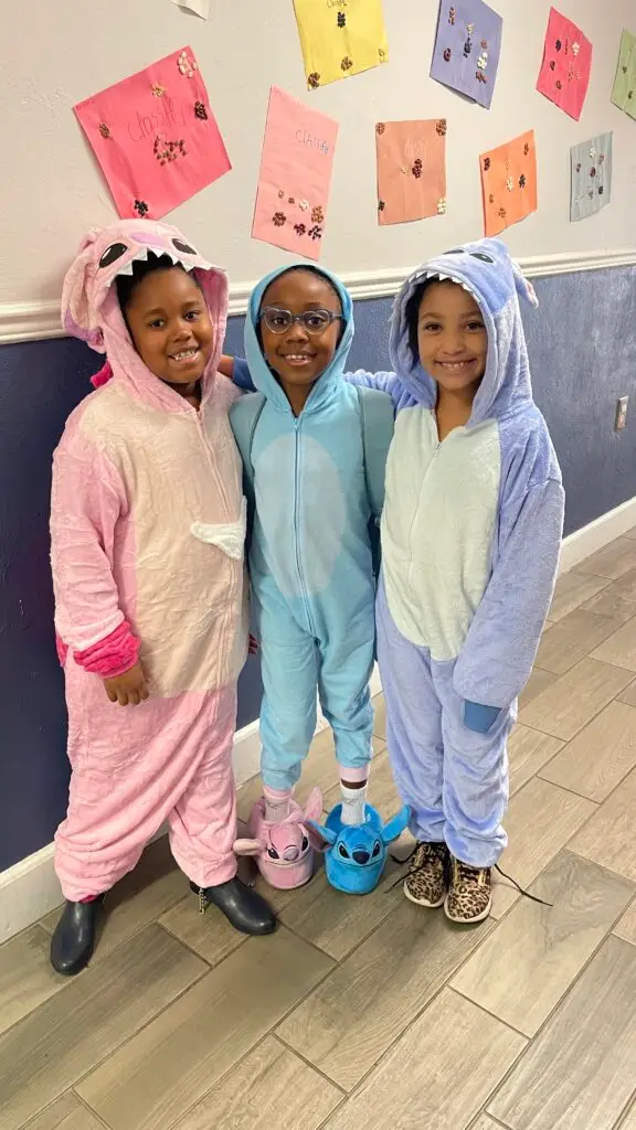 Three elementary students dressed in colorful pajamas and slippers on Pajama Day at Bethany Christian School.