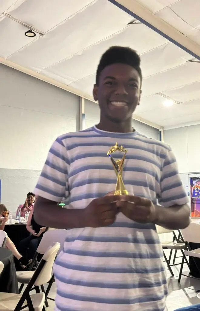 Bethany Christian School student proudly holding a trophy at the high school awards banquet.