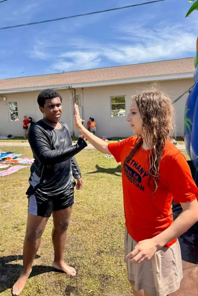 Bethany Christian School high school students giving high-fives during a Field Day water activity.