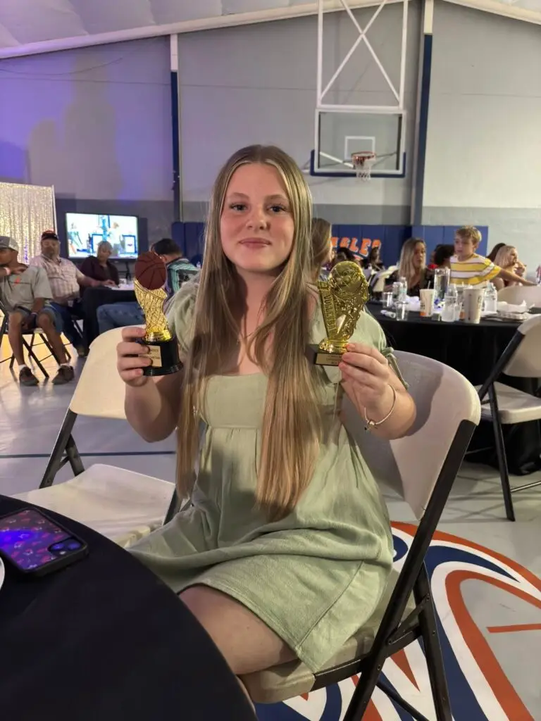 Bethany Christian School high school student holding multiple trophies at the awards ceremony.