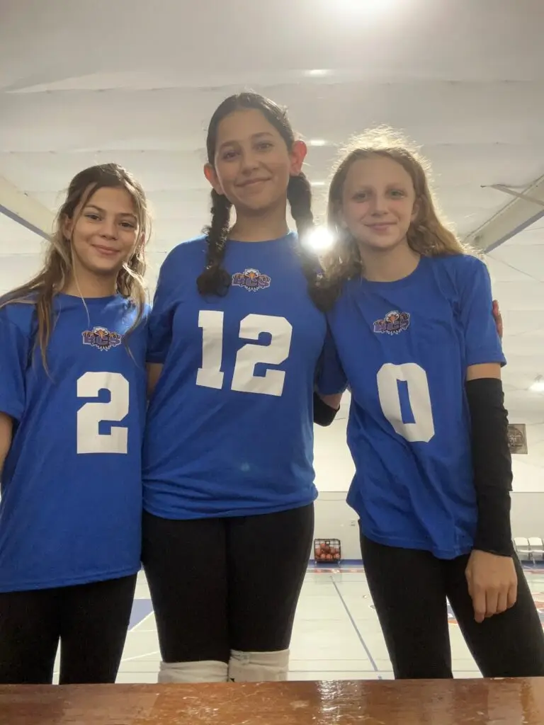 Bethany Christian School middle school girls posing in volleyball uniforms, representing athletics, teamwork, and school spirit.