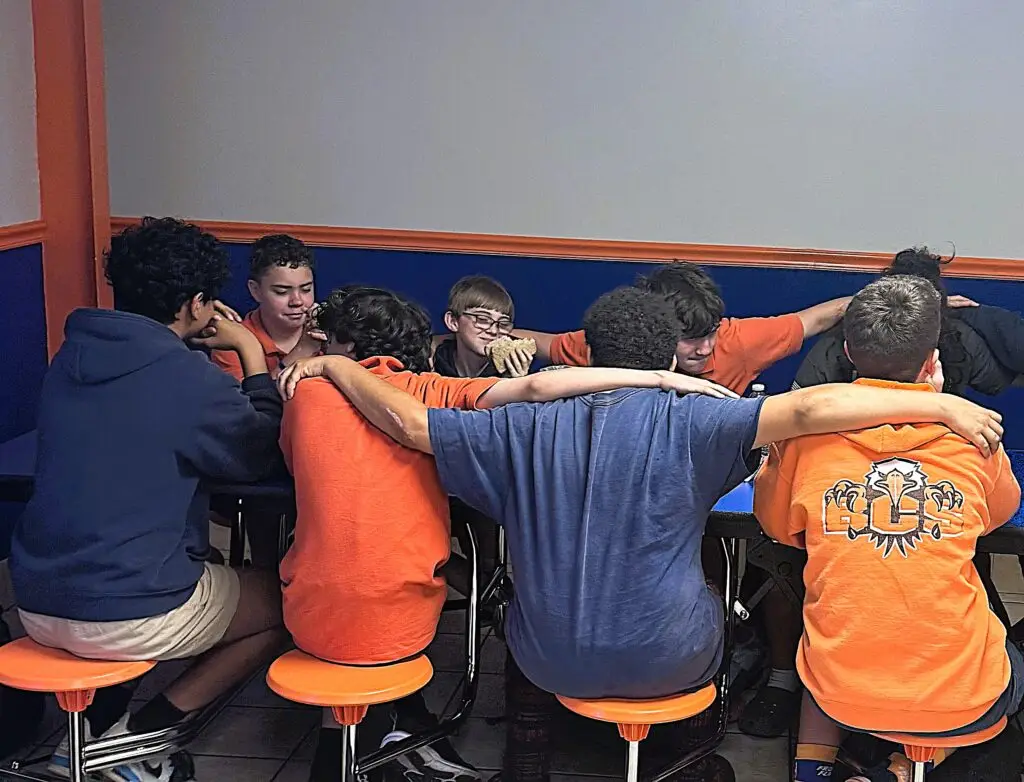 Bethany Christian School middle school boys gathered in prayer and fellowship, growing spiritually through community and mentorship.