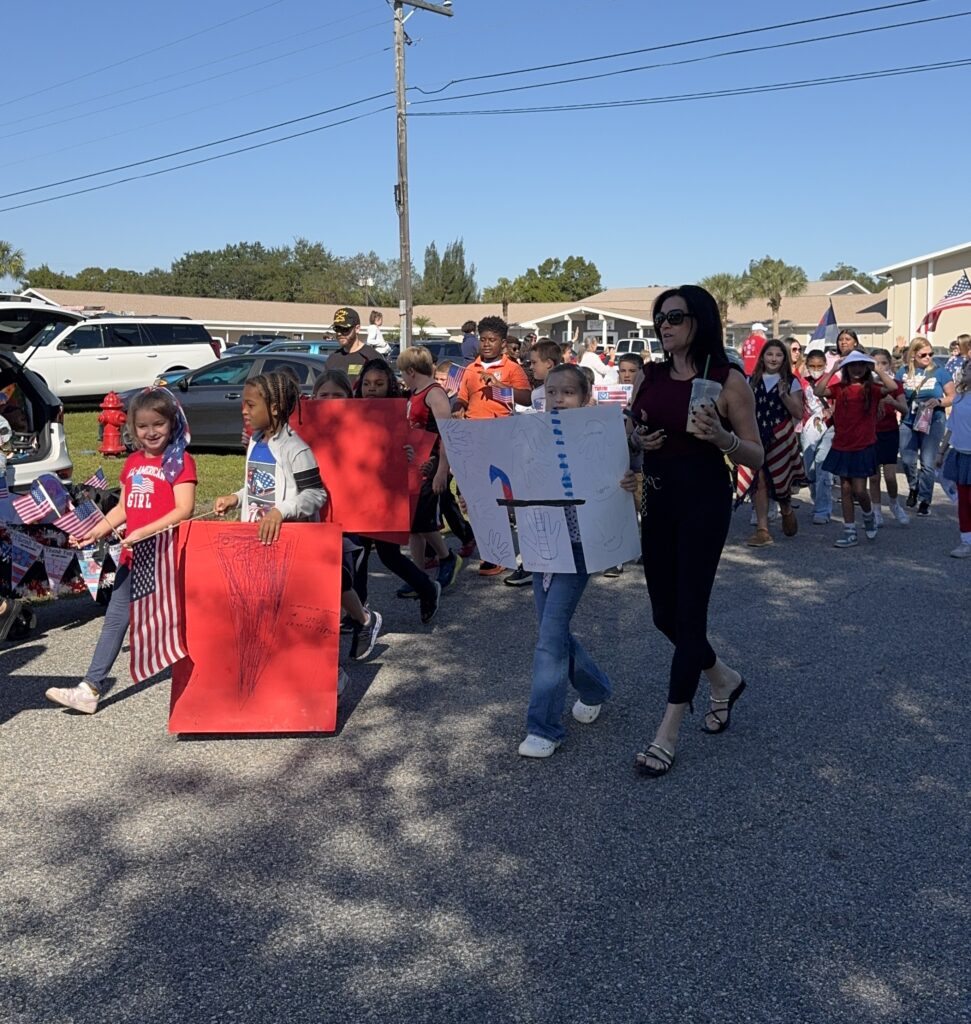 Bethany Christian School students and parents walking together in a community parade, showing partnership, character development, and Christian values.